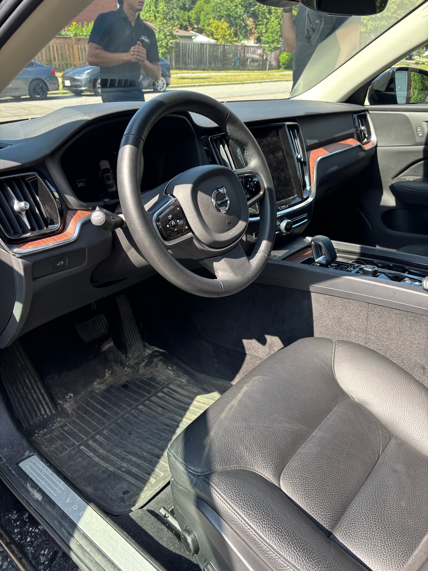 Dirty floor mat and dashboard of a Volvo before detailing